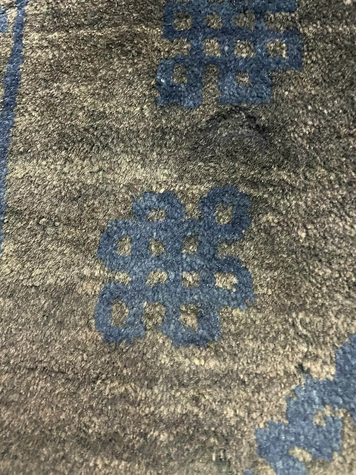 Handmade Chinese rug with dark background and detailed patterns.

