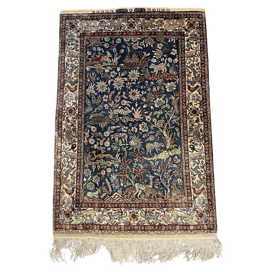 Handmade vintage Turkish Hereke silk rug with floral and animal motifs.

