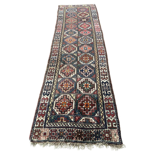 Handmade antique Caucasian Genje runner rug with geometric patterns.

