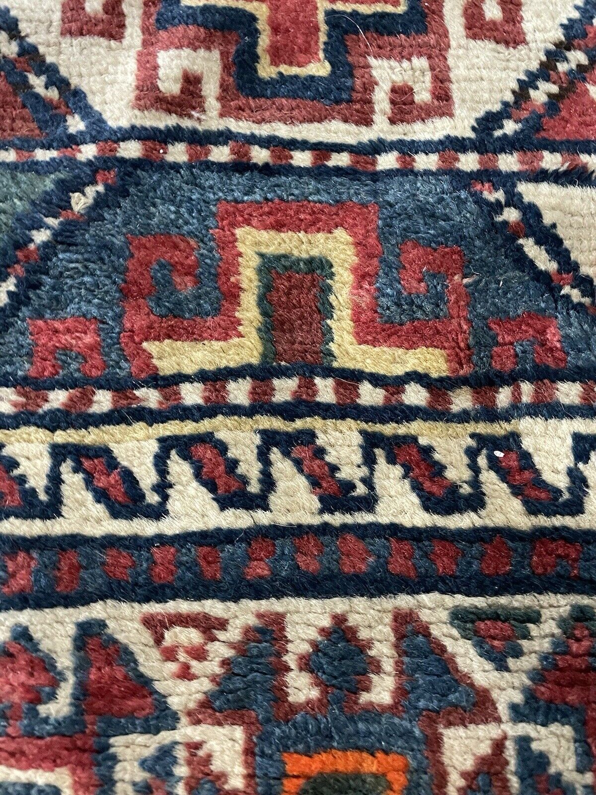 Deep red and blue antique runner rug with vibrant motifs.

