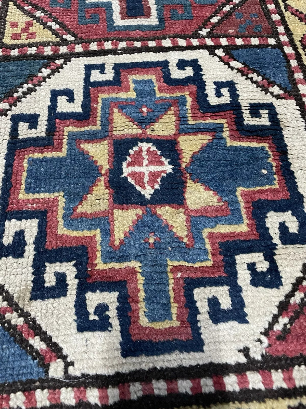 Soft beige accents contrasting deep red hues in a Genje runner.

