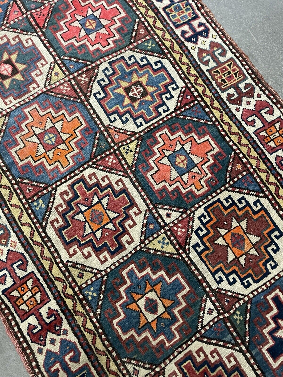 Traditional wool rug from the Caucasus region with unique motifs.

