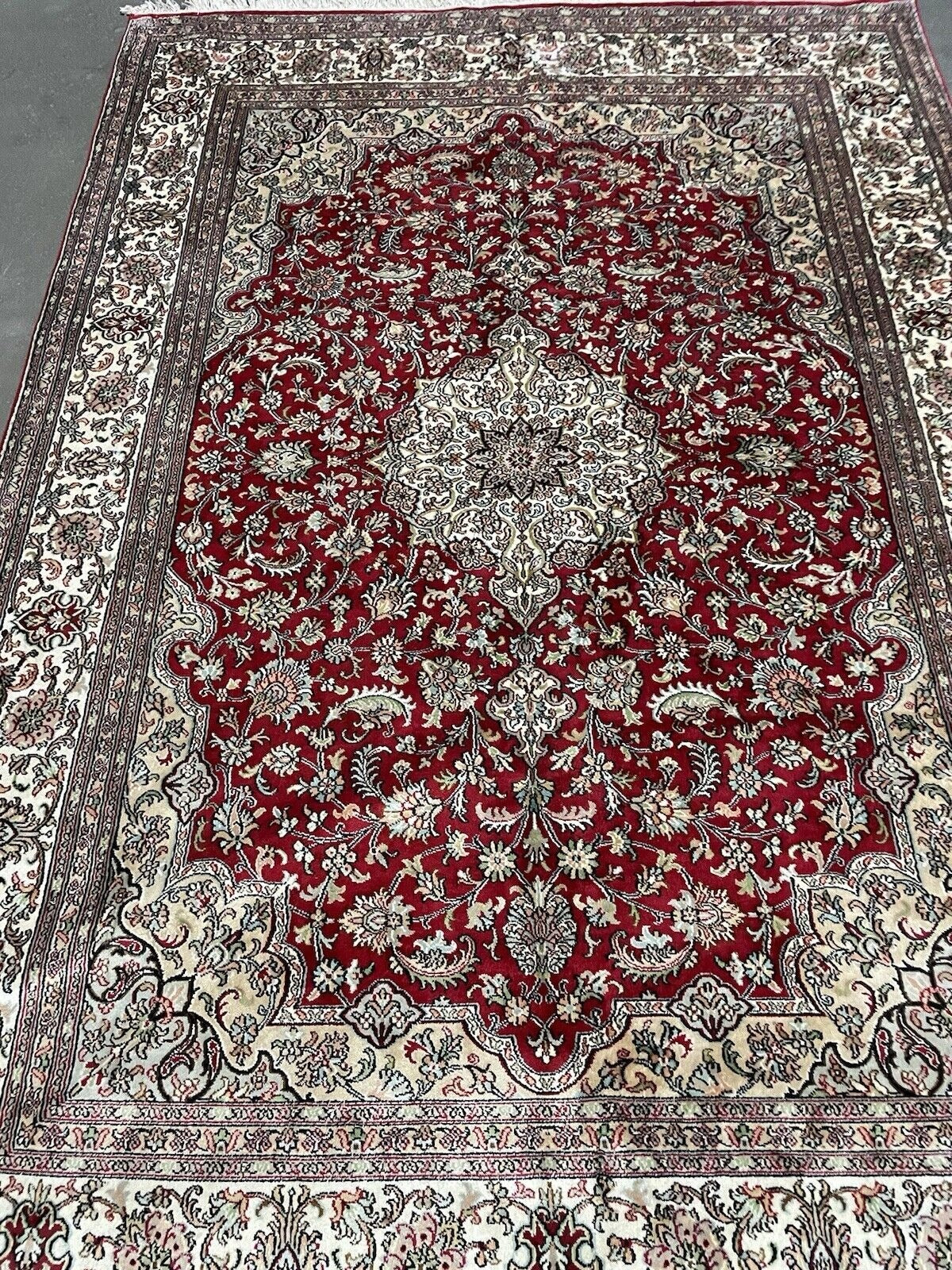 Intricate flower and vine motifs on vintage Persian rug

