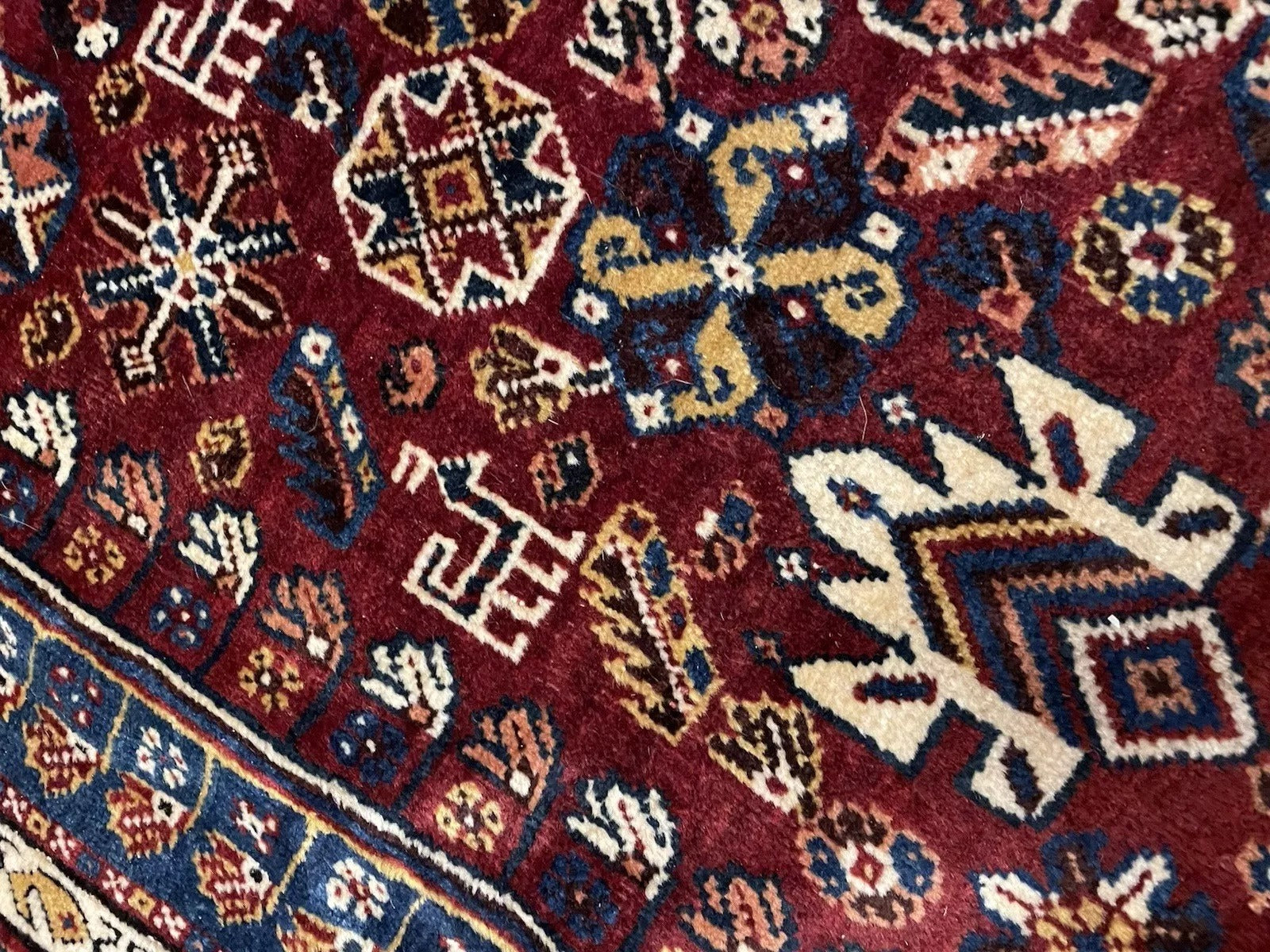 Close-up of stylized animal figures on wool rug

