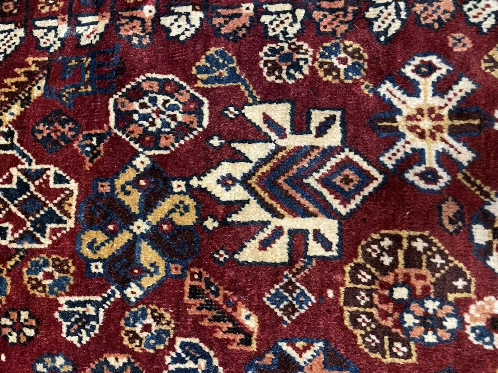 Hand-knotted wool pile detail on tribal Persian rug

