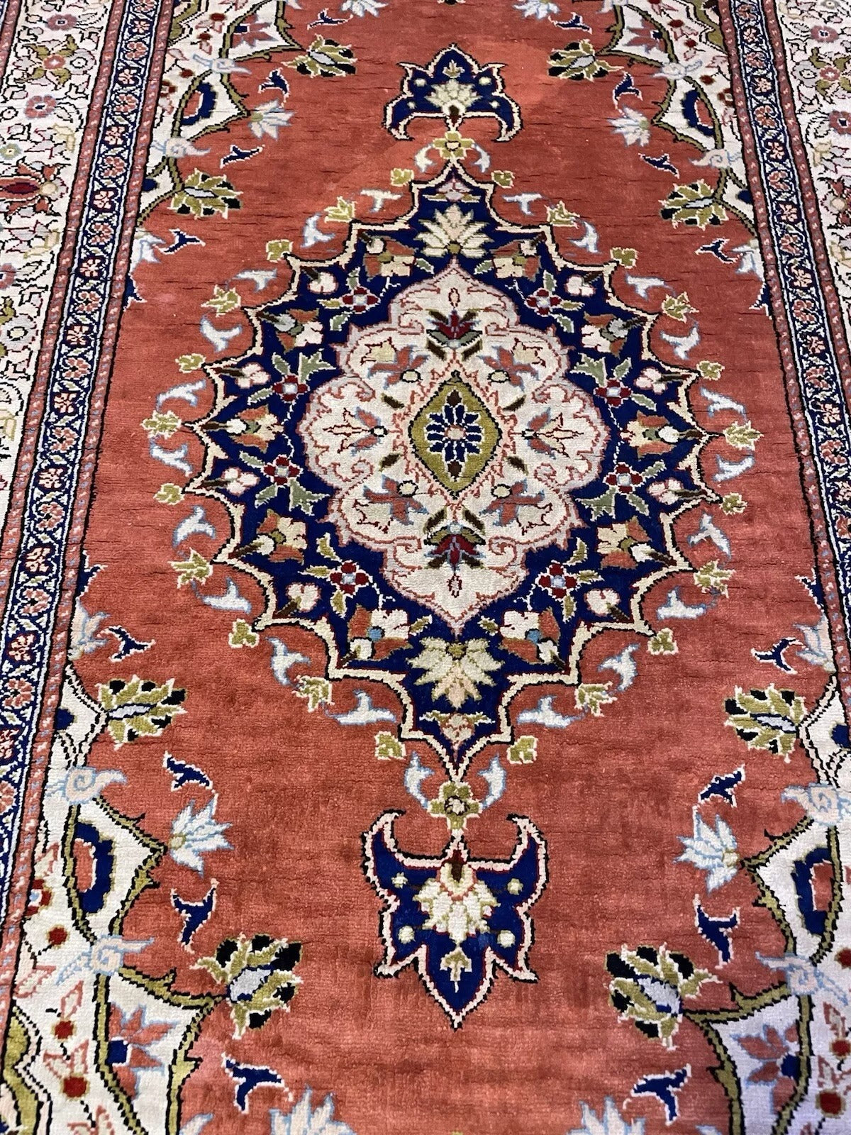 Floral and geometric composition on Keyseri rug

