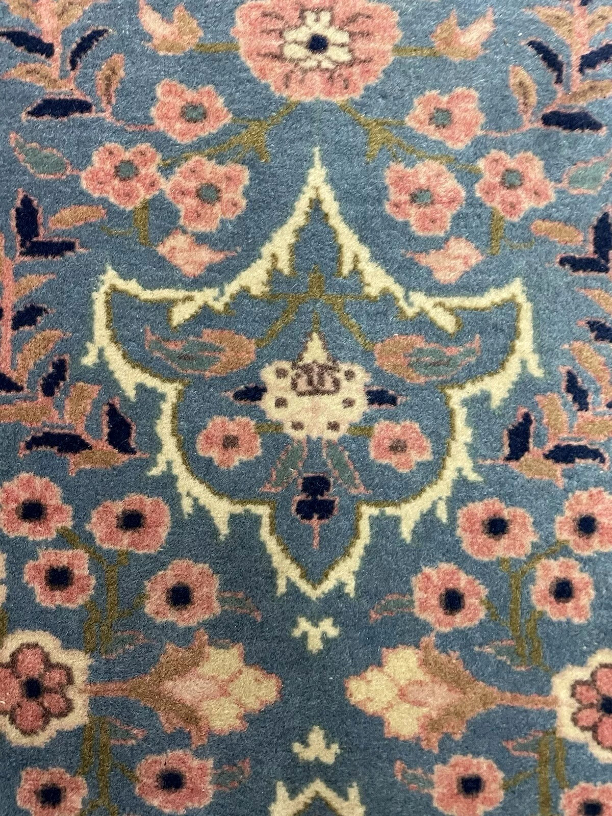 Overhead view of antique Persian rug’s symmetrical layout
