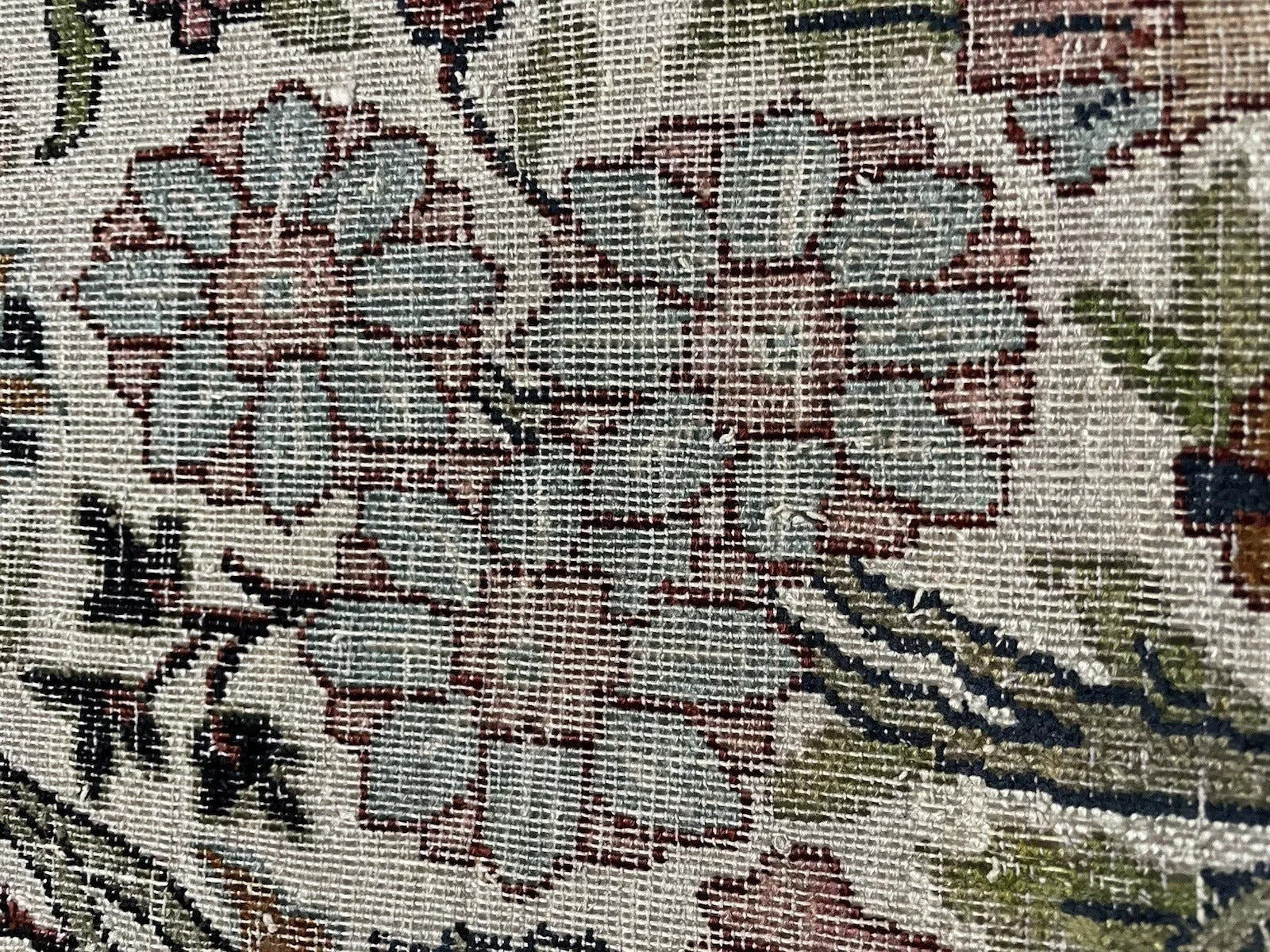 Texture detail highlighting the soft, aged wool pile of the antique carpet.

