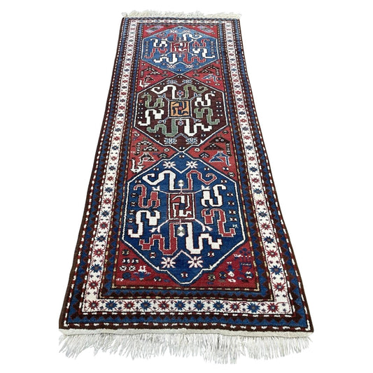 Full top view of the antique Caucasian Kazak rug showing the two large medallions on a red field.

