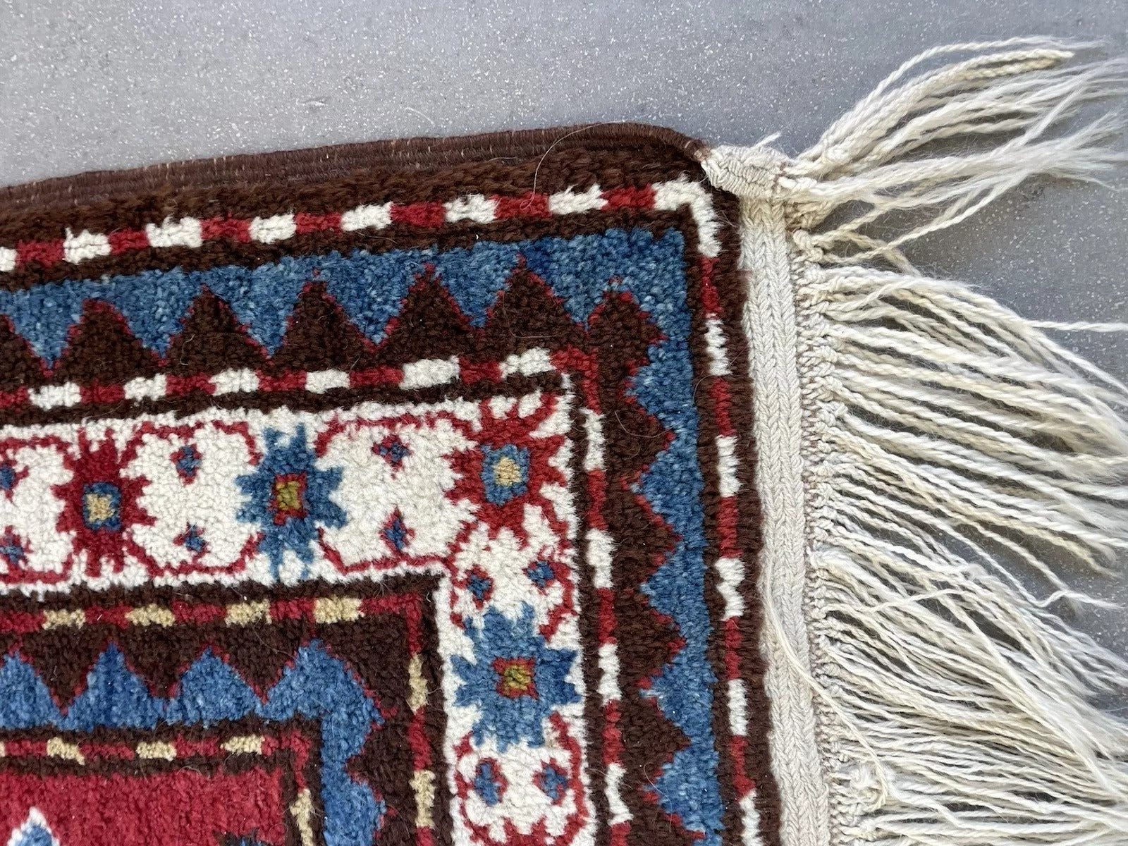 Angle shot capturing the vibrant intensity of the rug's primary red background color.

