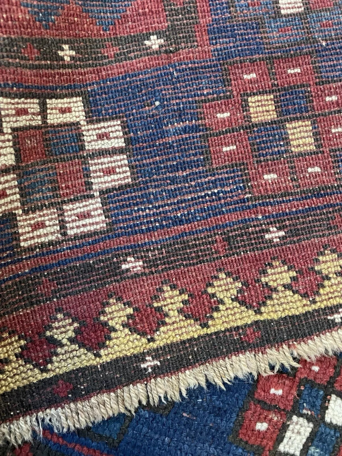View highlighting the vibrant contrast between the deep red field and navy blue motifs.

