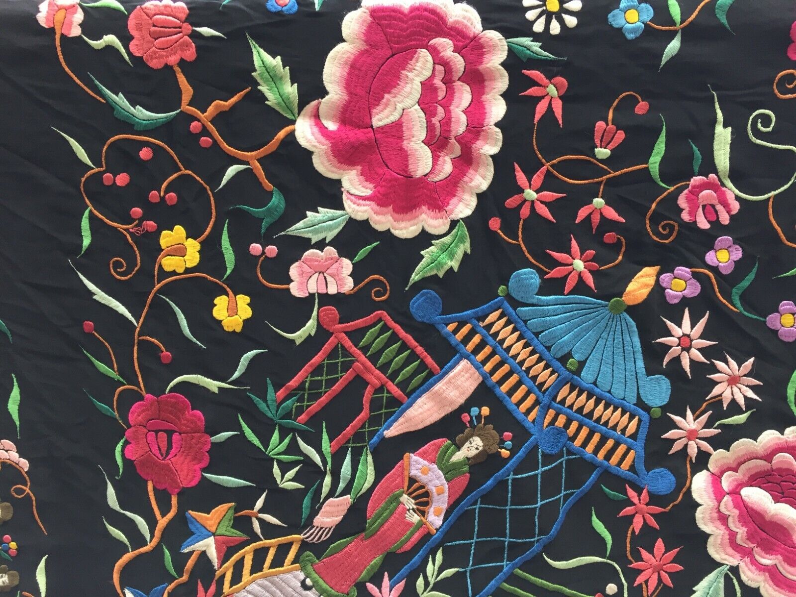 Artistic display of the shawl as a statement piece on a clothing rack, showcasing its dramatic black color and intricate embroideries
