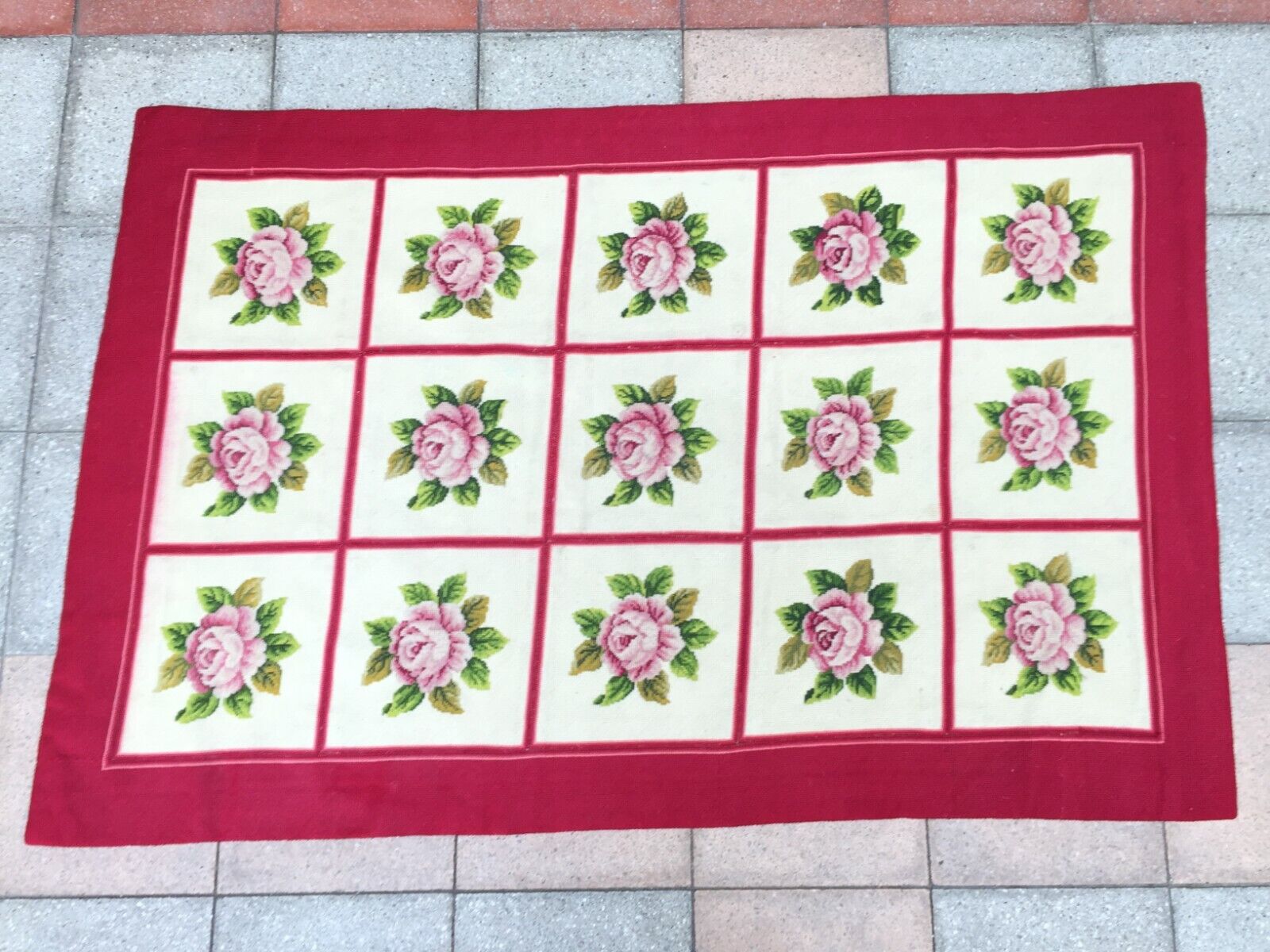 Close-up of the central grid pattern with needlepoint stitched pink roses and green leaves