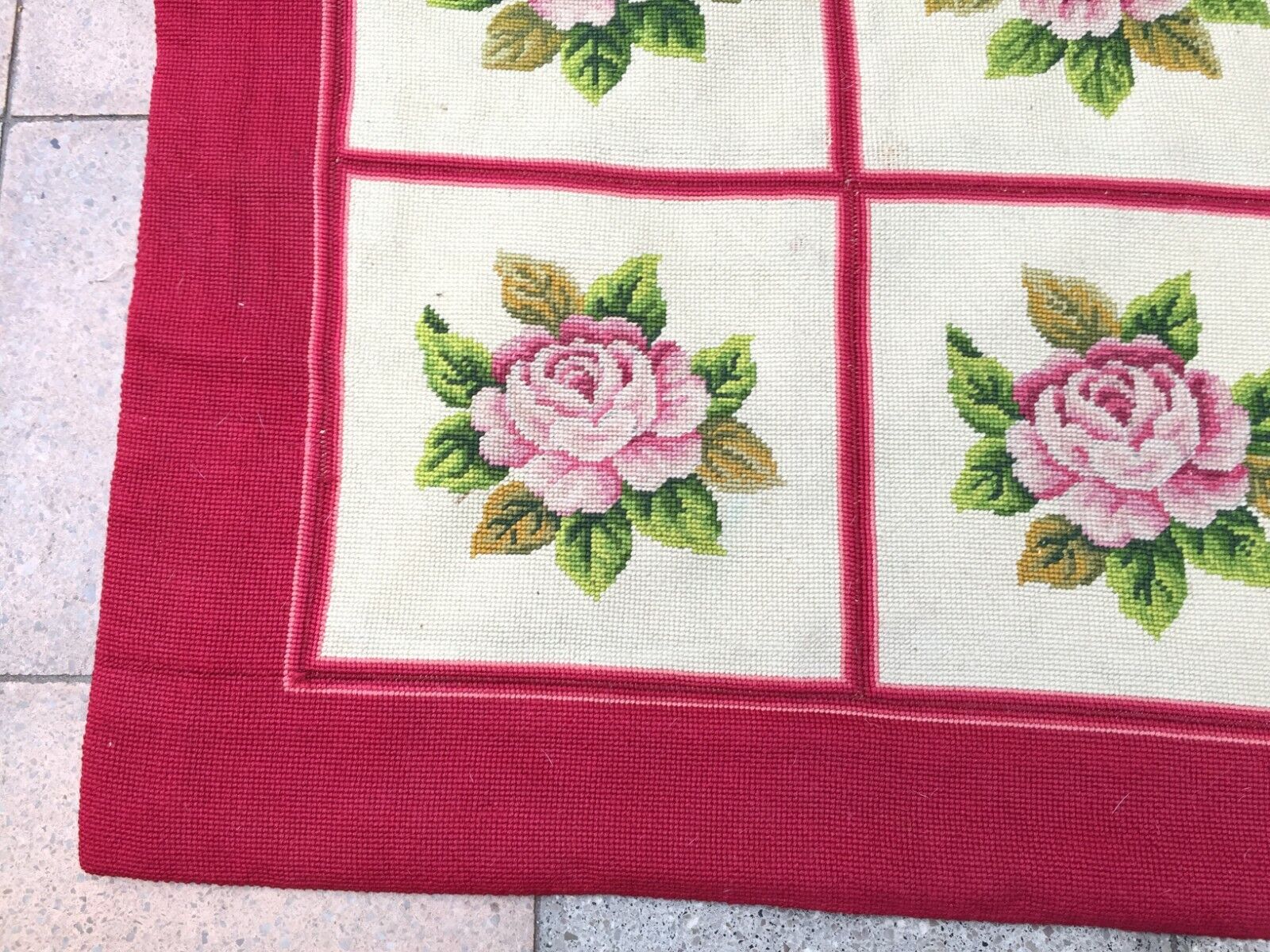 Overhead shot of the rug displaying its symmetrical arrangement of roses and leaves