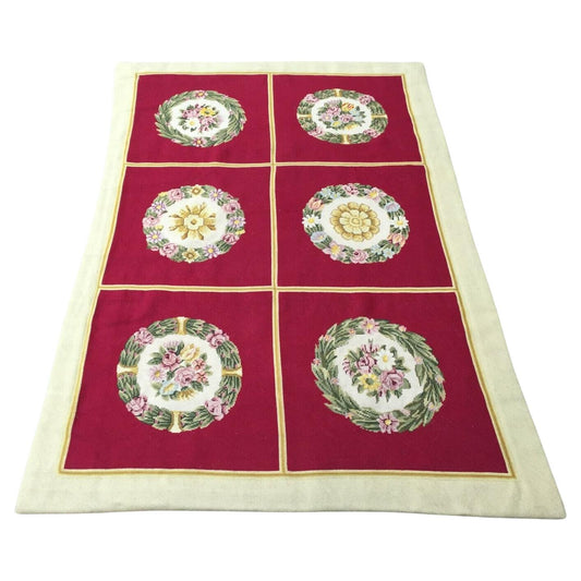 Handmade Vintage French Needlepoint Rug featuring six circular floral designs on a red central area, surrounded by a cream border
