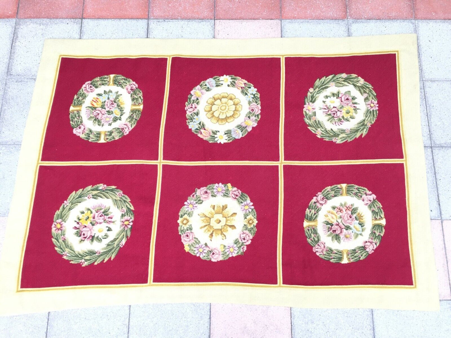 Close-up of the central red area with intricately needlepointed circular floral designs