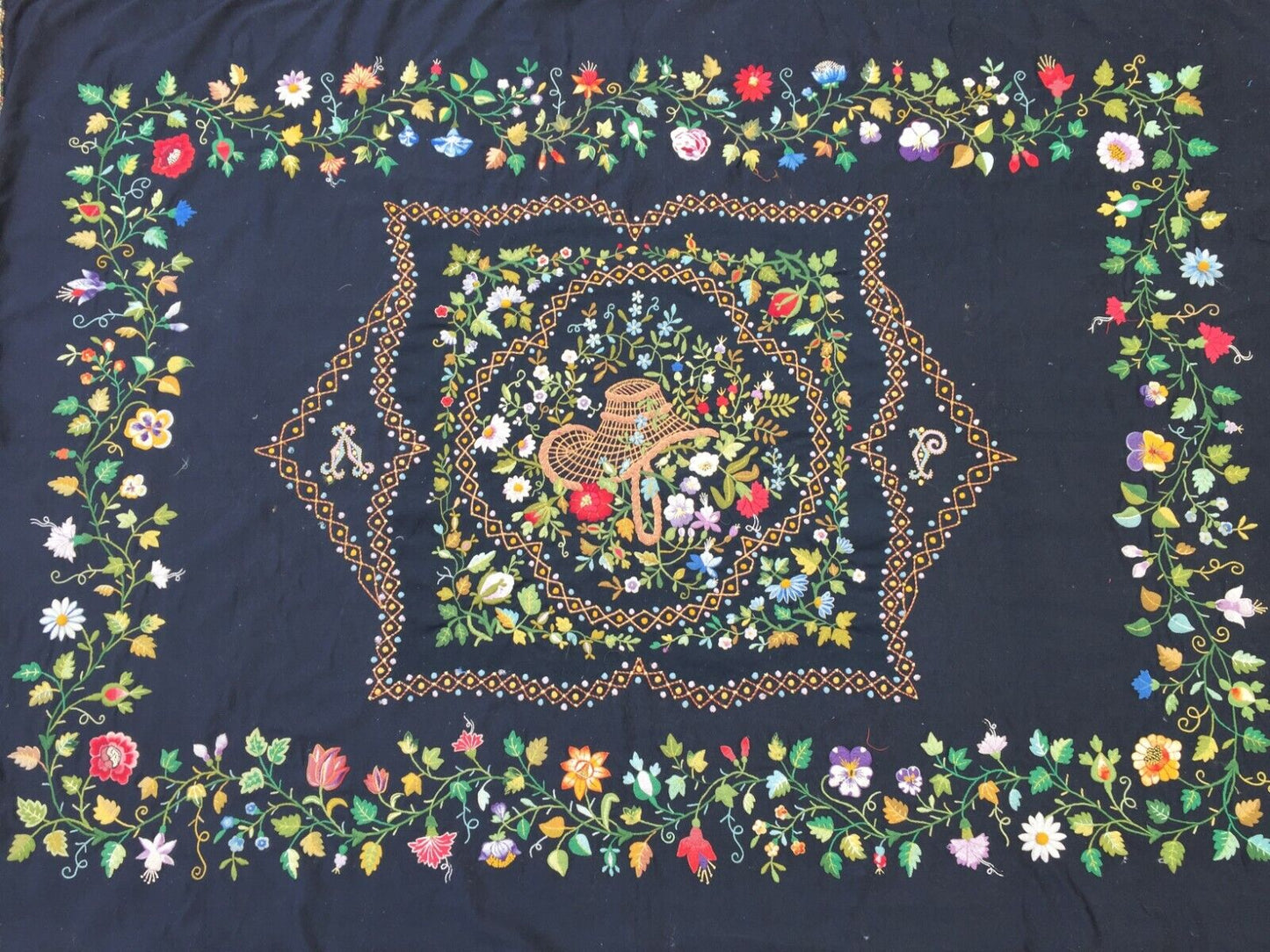 Close-up of the detailed needlepoint depiction at the rug's centerpiece
