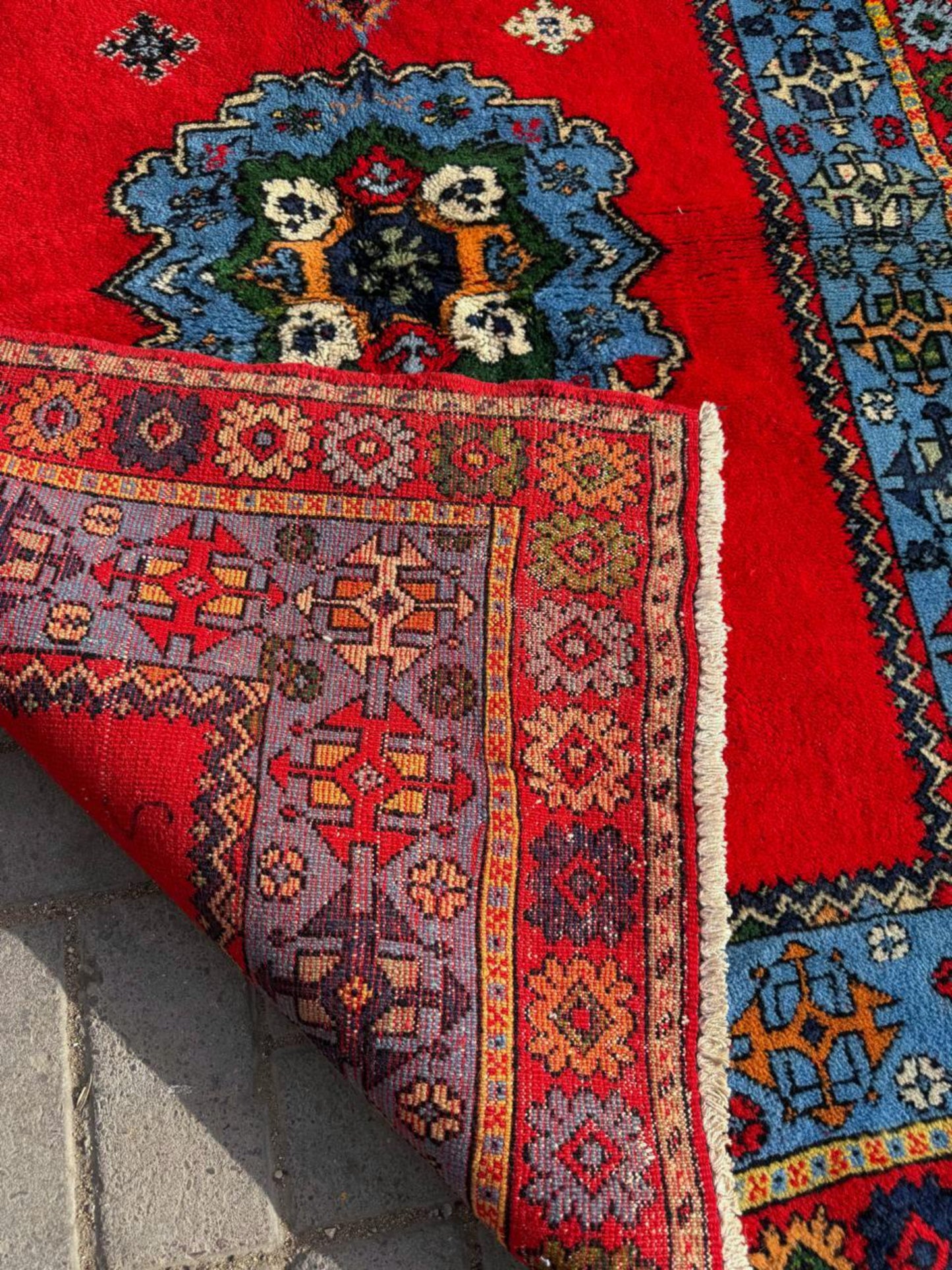 Close-up of geometric medallion in blue and red

