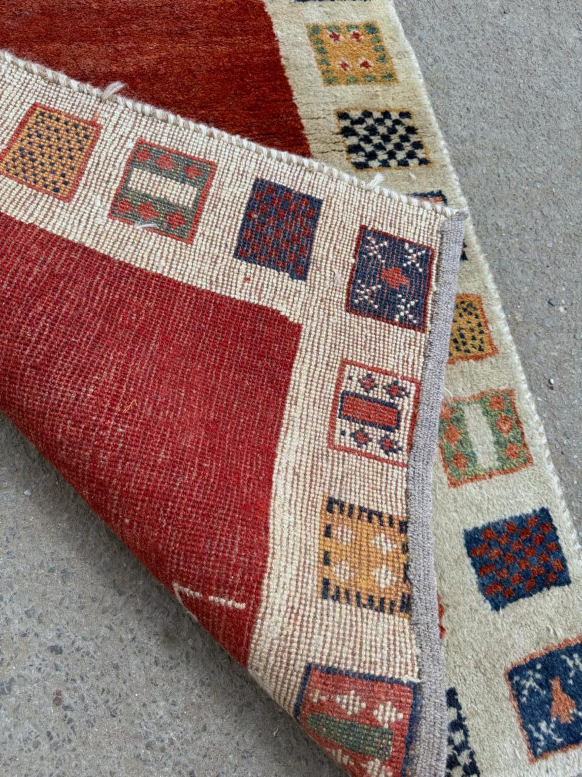 Close-up detail of a stylized animal motif on the open field.

