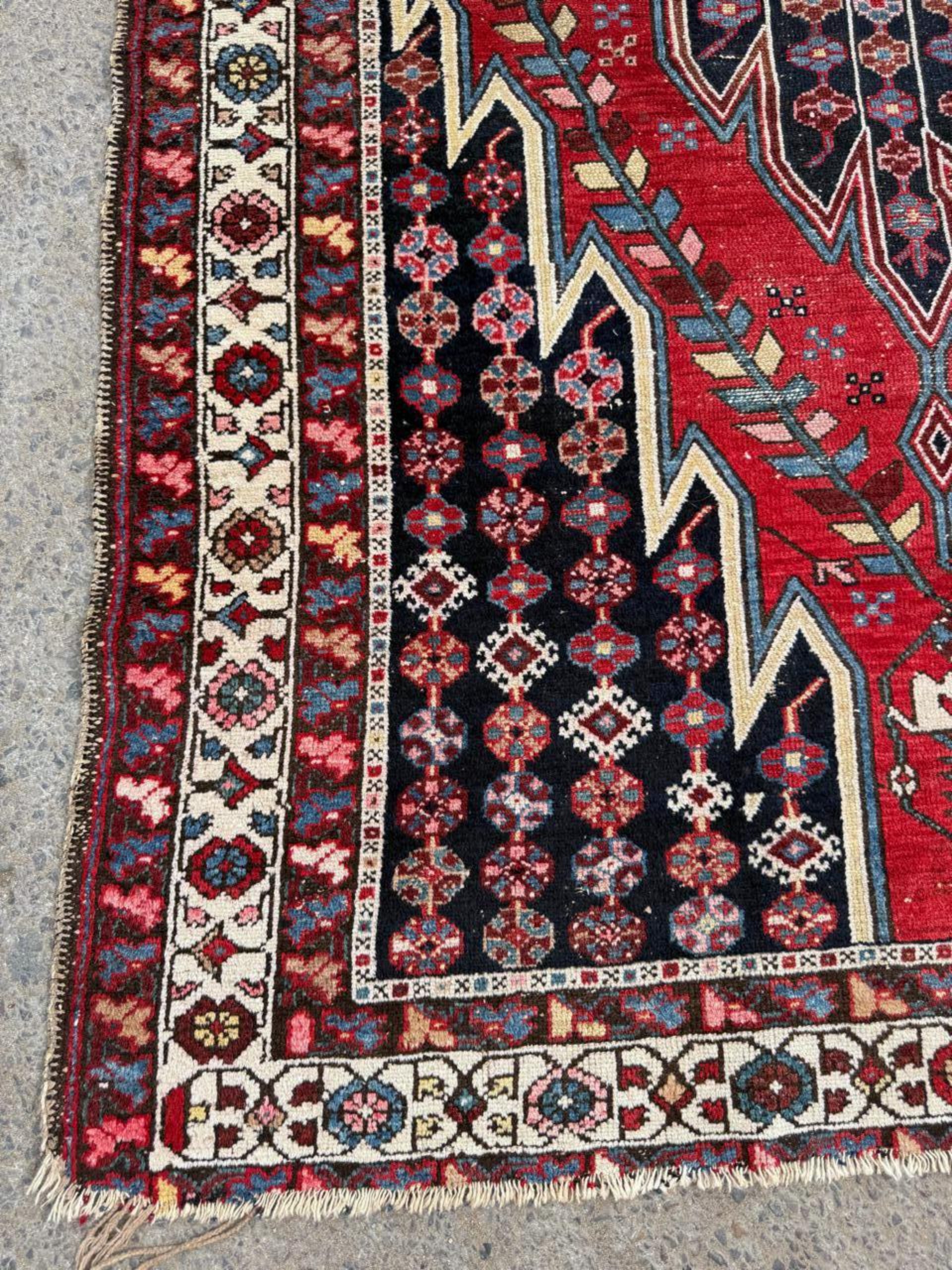Close-up detail of the Herati motif featuring a central flower and encircling leaves.

