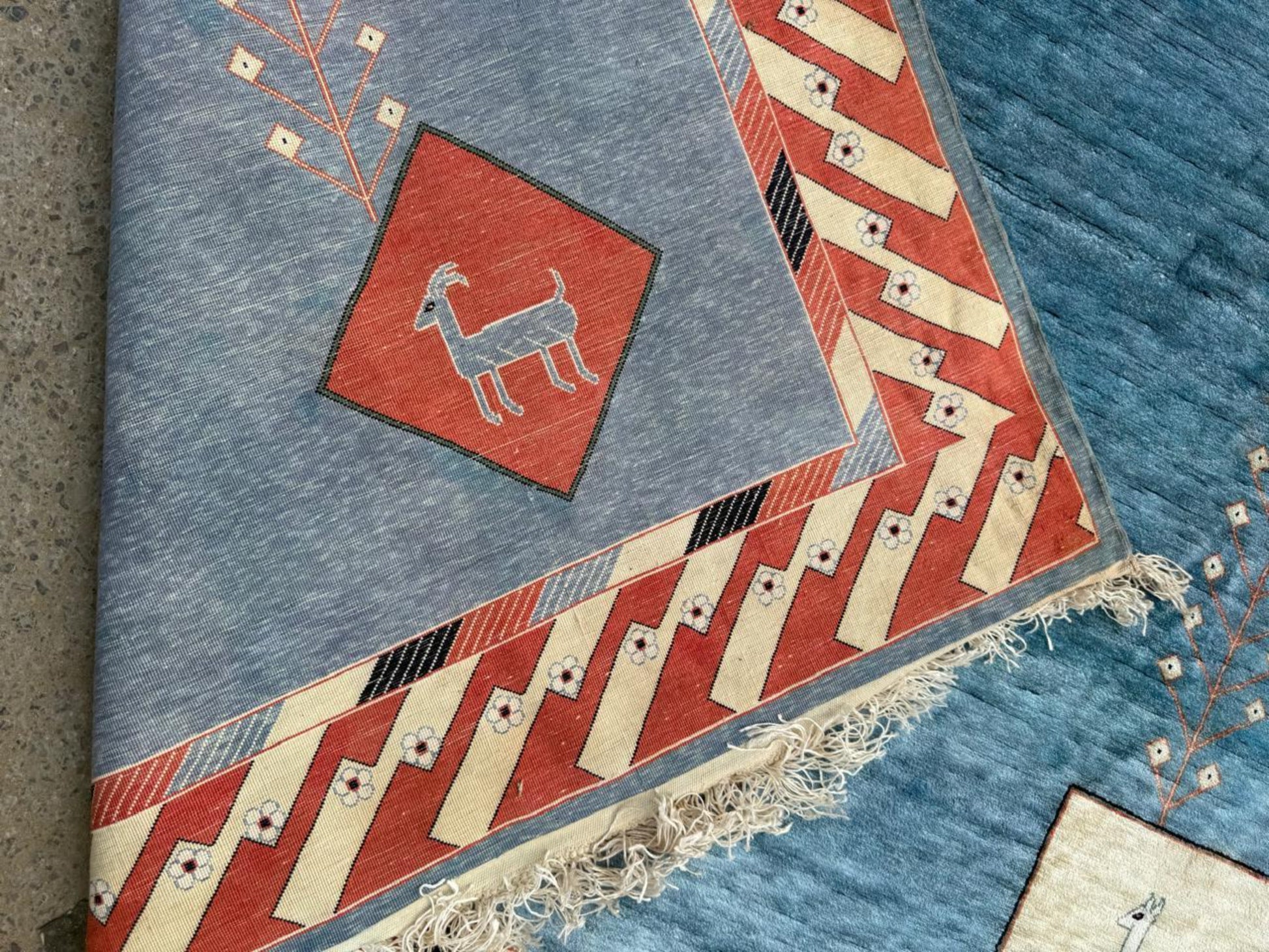 Shot focusing on the intricate "Greek key" border pattern on the rug's edge.

