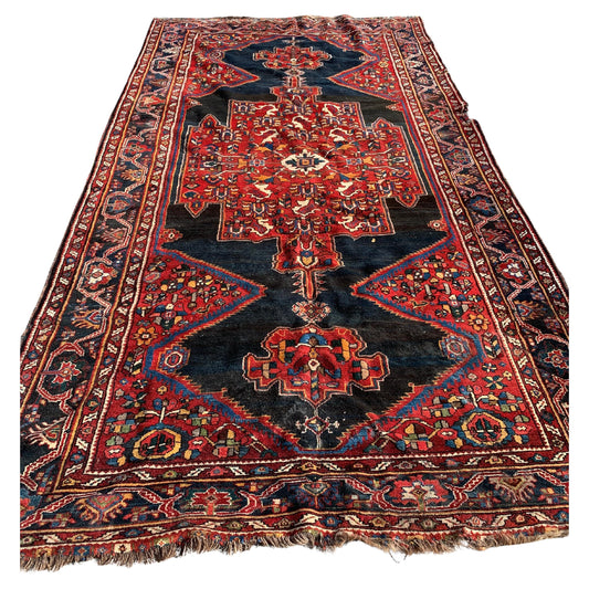 Handmade antique Persian Luri rug with vibrant geometric patterns.

