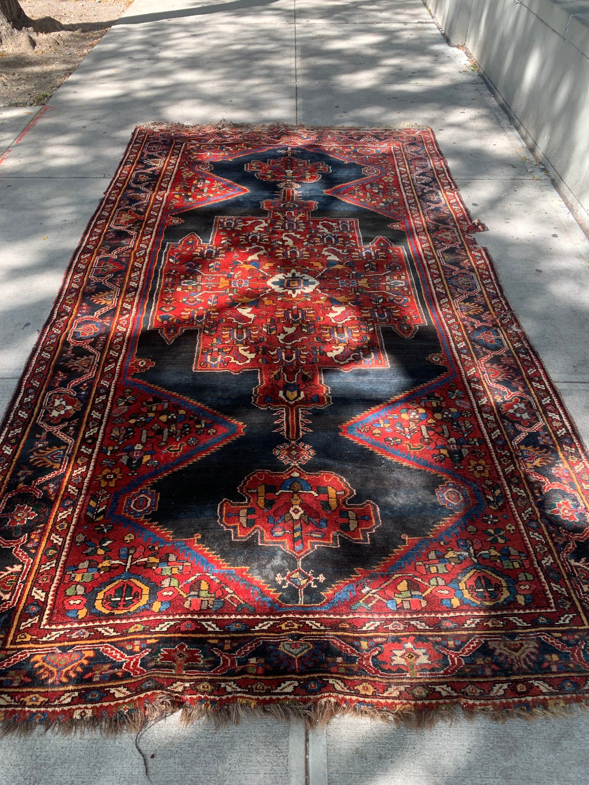 Close-up of hand-knotted wool detailing on a Persian tribal rug.
