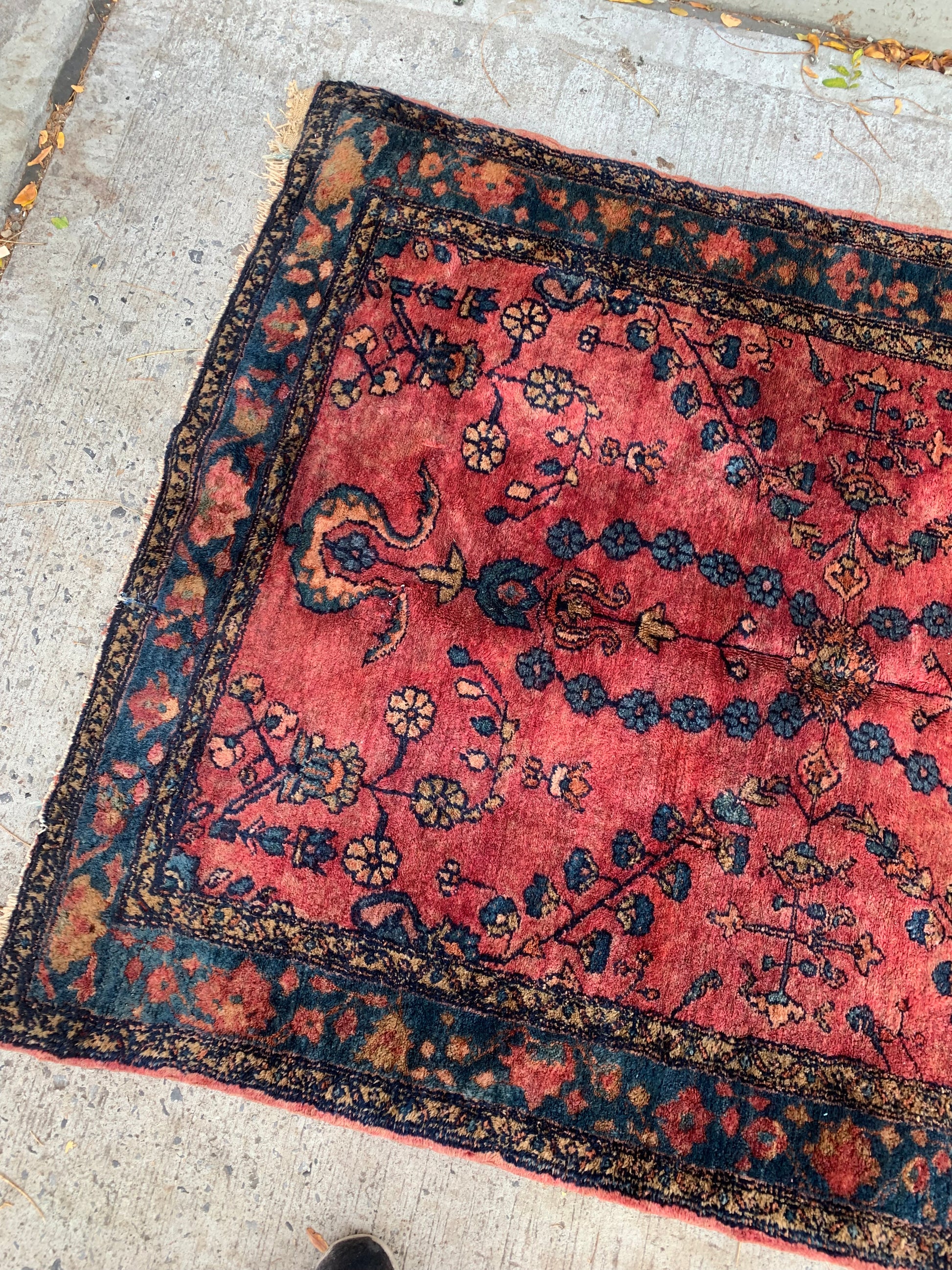 Vibrant red field and floral motifs on a Persian Lilihan rug.
