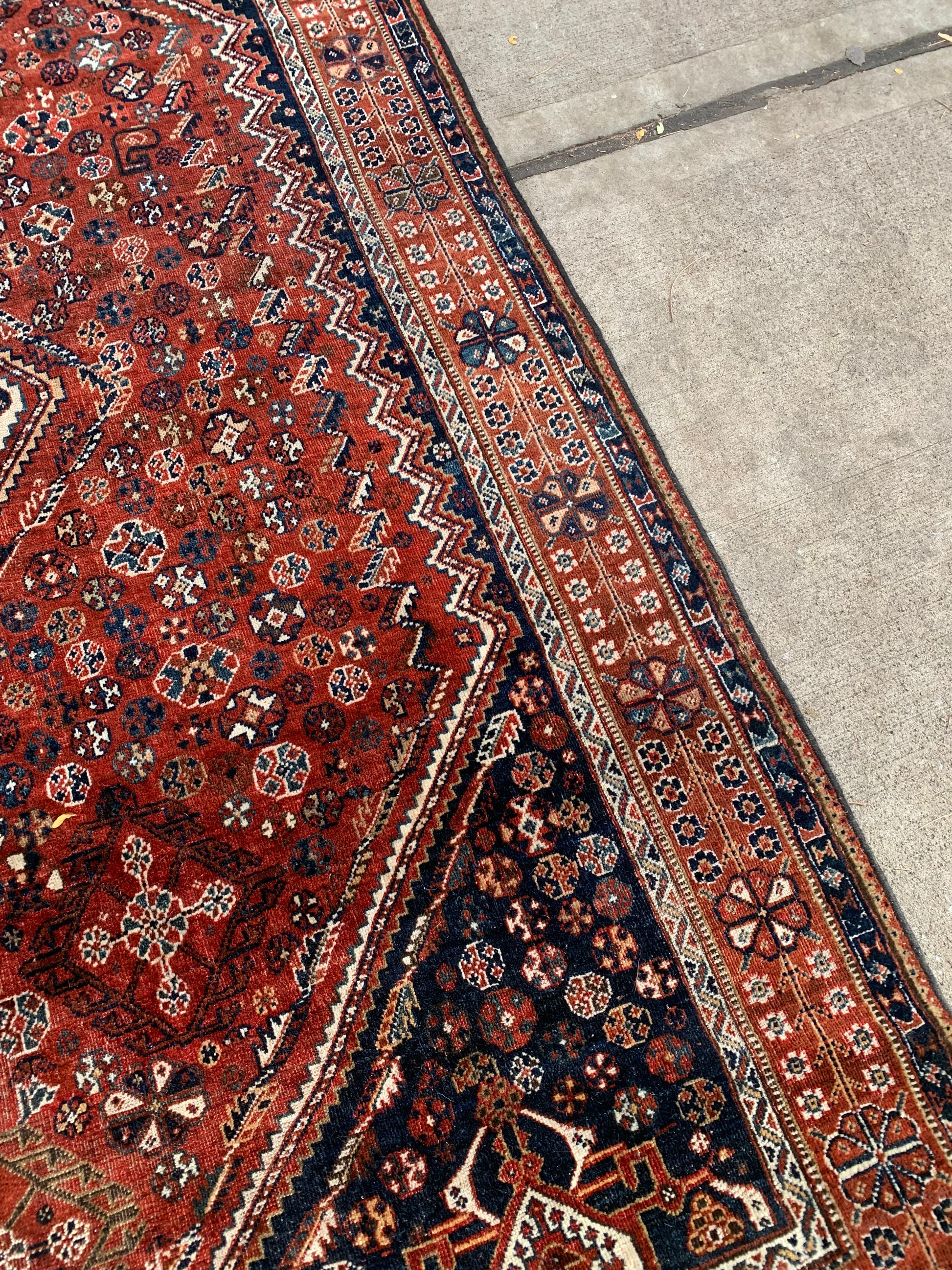 Intricate tribal patterns on an antique Persian rug.
