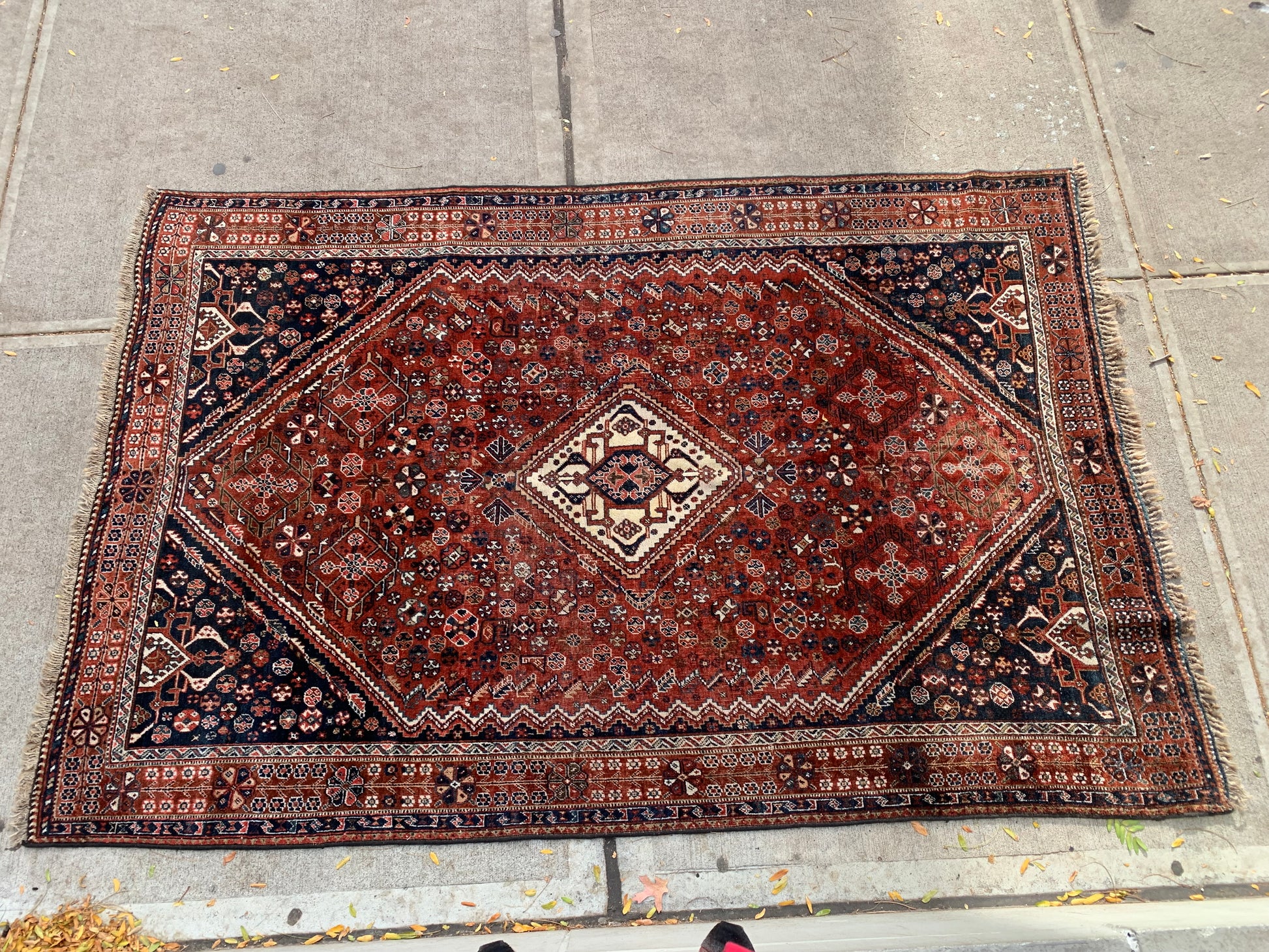 Central diamond medallion design on a Persian Qashqai rug.
