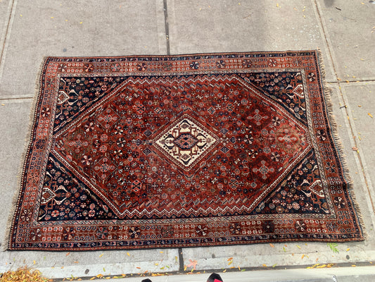 Central diamond medallion design on a Persian Qashqai rug.
