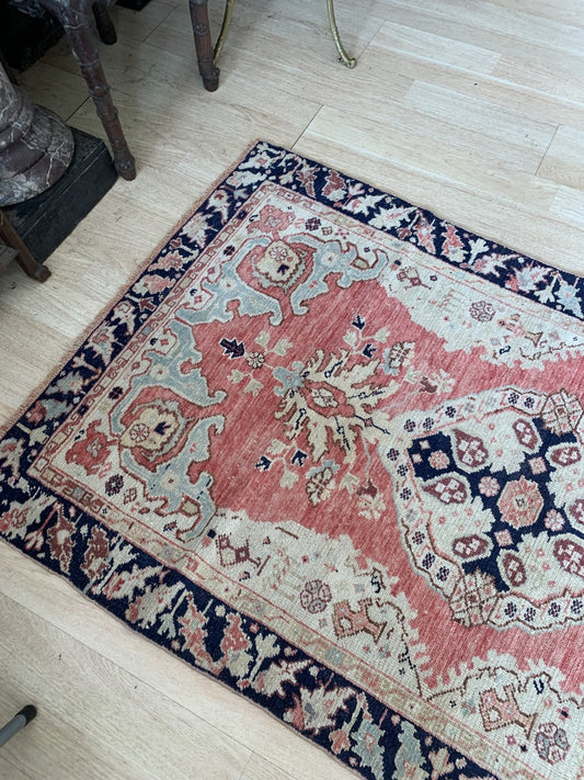 Close-up of the intricate floral and vine patterns on the antique rug.
