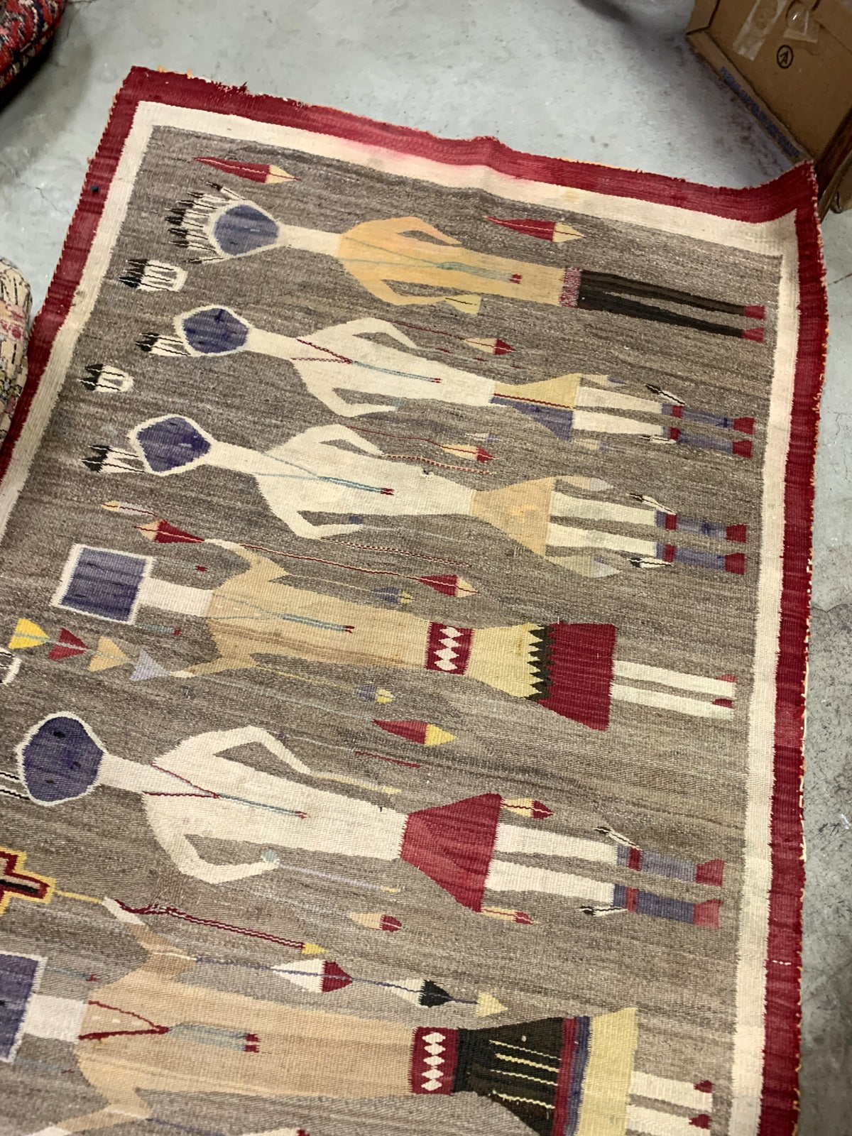Close-up of intricate Yei figure patterns on a Navajo wool rug
