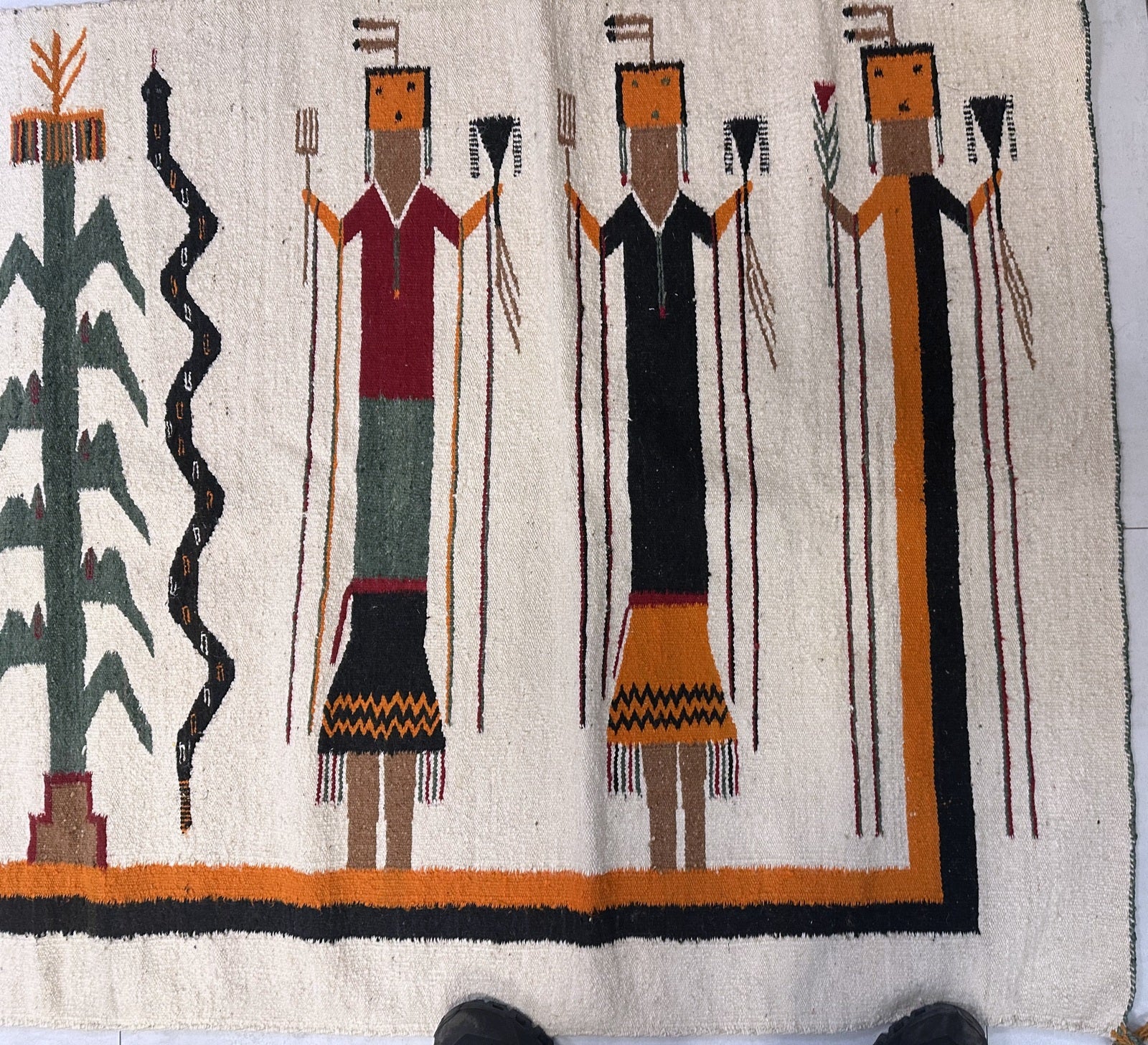 Hand-woven antique Navajo rug with spiritual figures.

