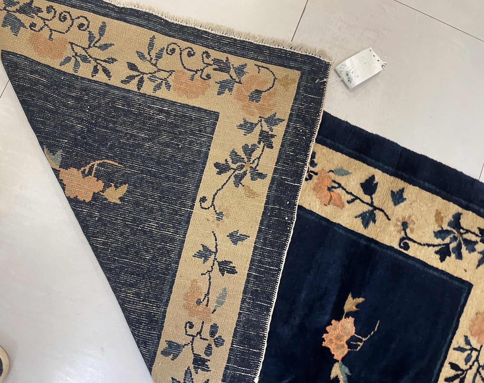 Detailed view of the ochre-yellow border with flourishing vine design.


