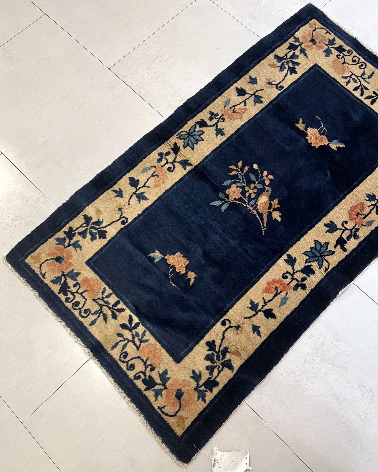 Full view of the rug showcasing the central bird and branch composition.


