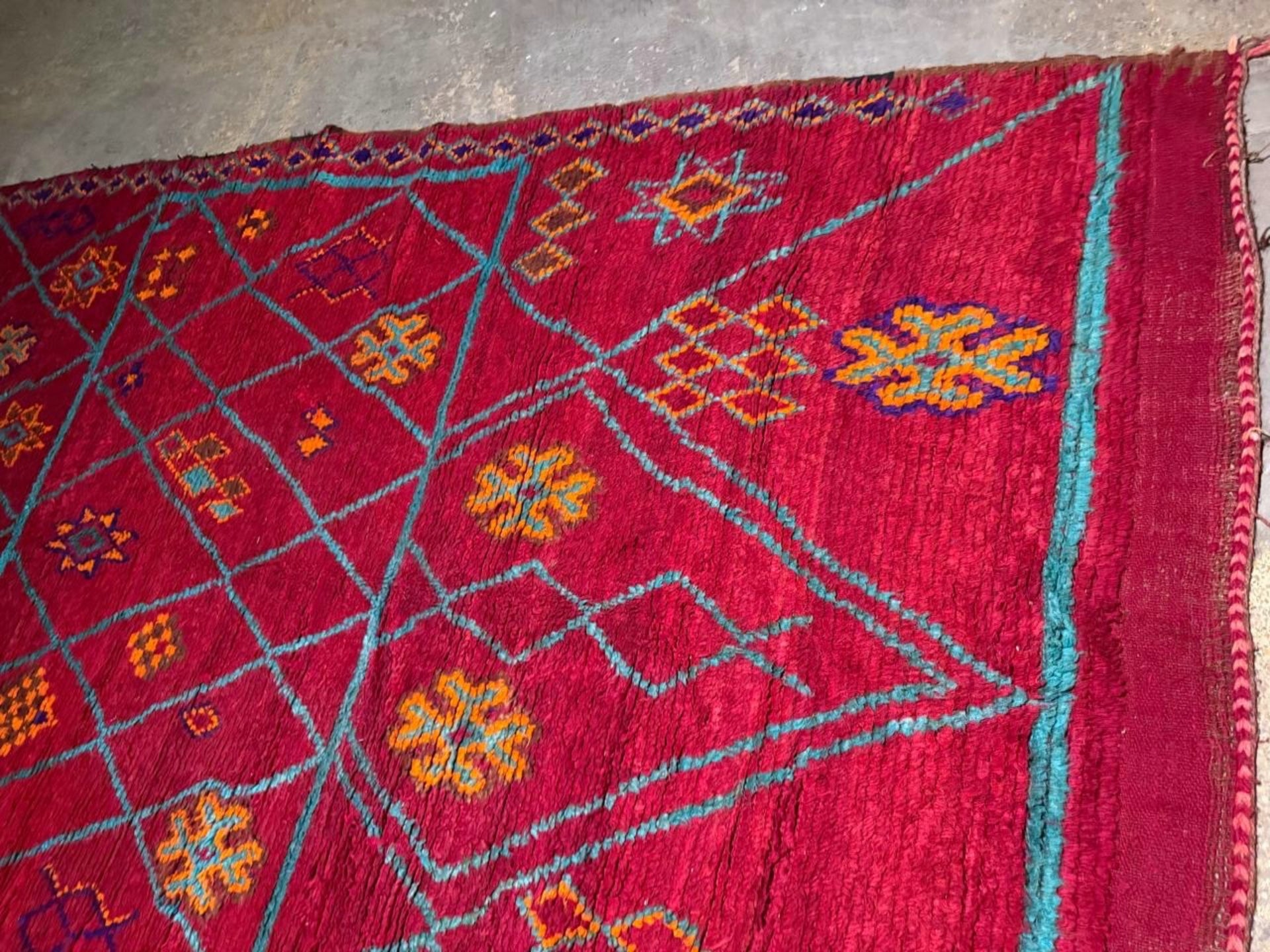 Vibrant fuchsia red field with teal blue lattice work

