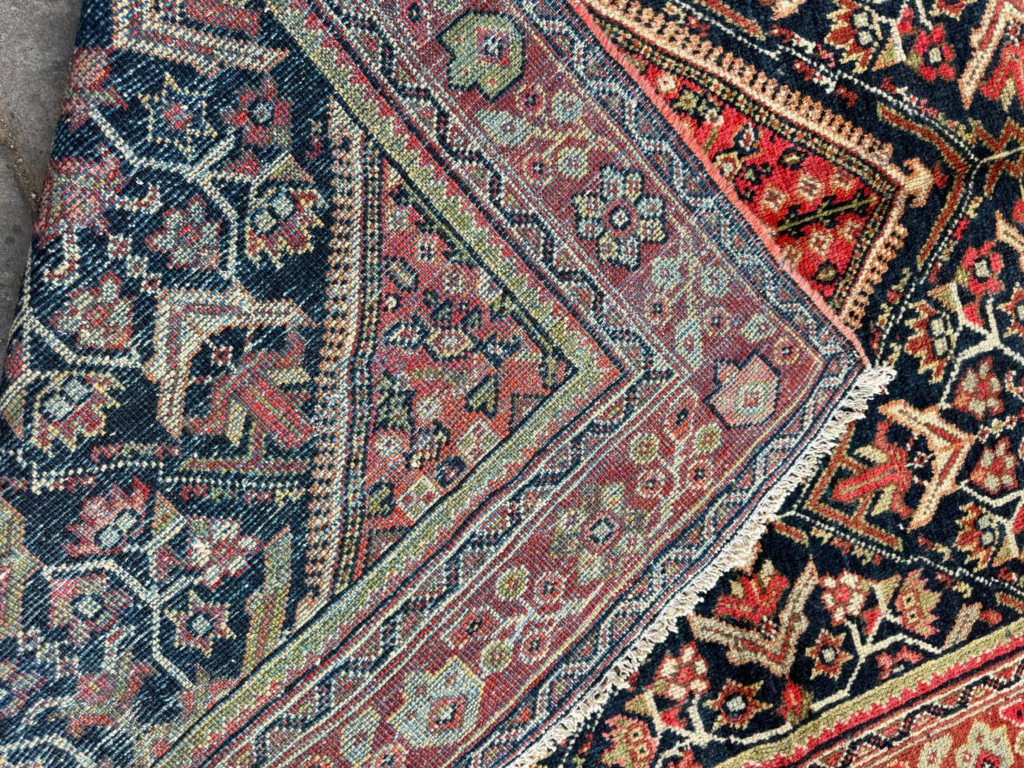 Detail of the rich terracotta red elements within the rug's design.

