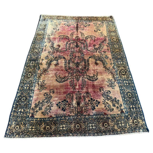 Full top view of the antique Persian Sarouk rug showing the central medallion on a light field.

