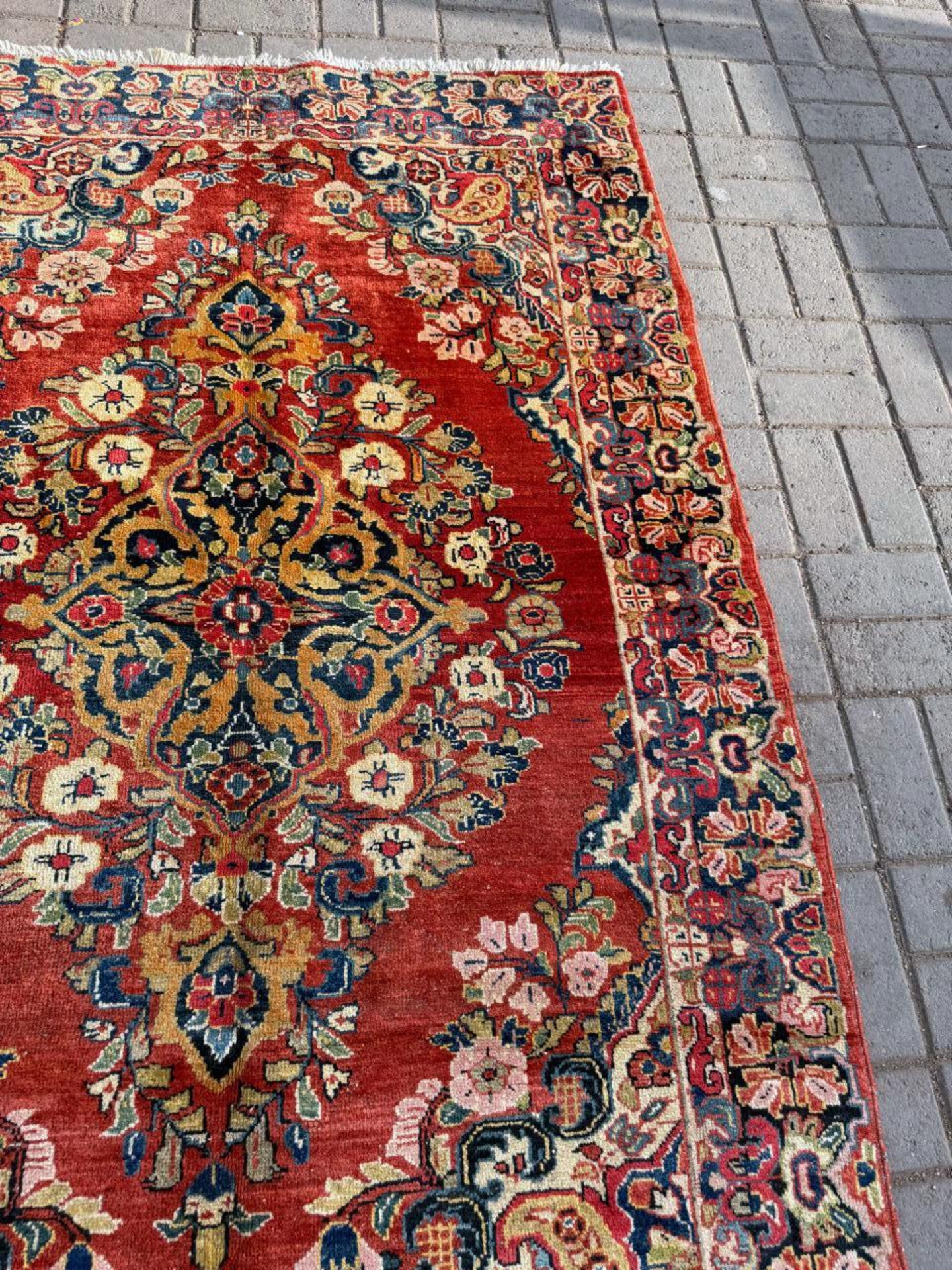 Close-up of the deep navy blue motifs contrasting against the red field.

