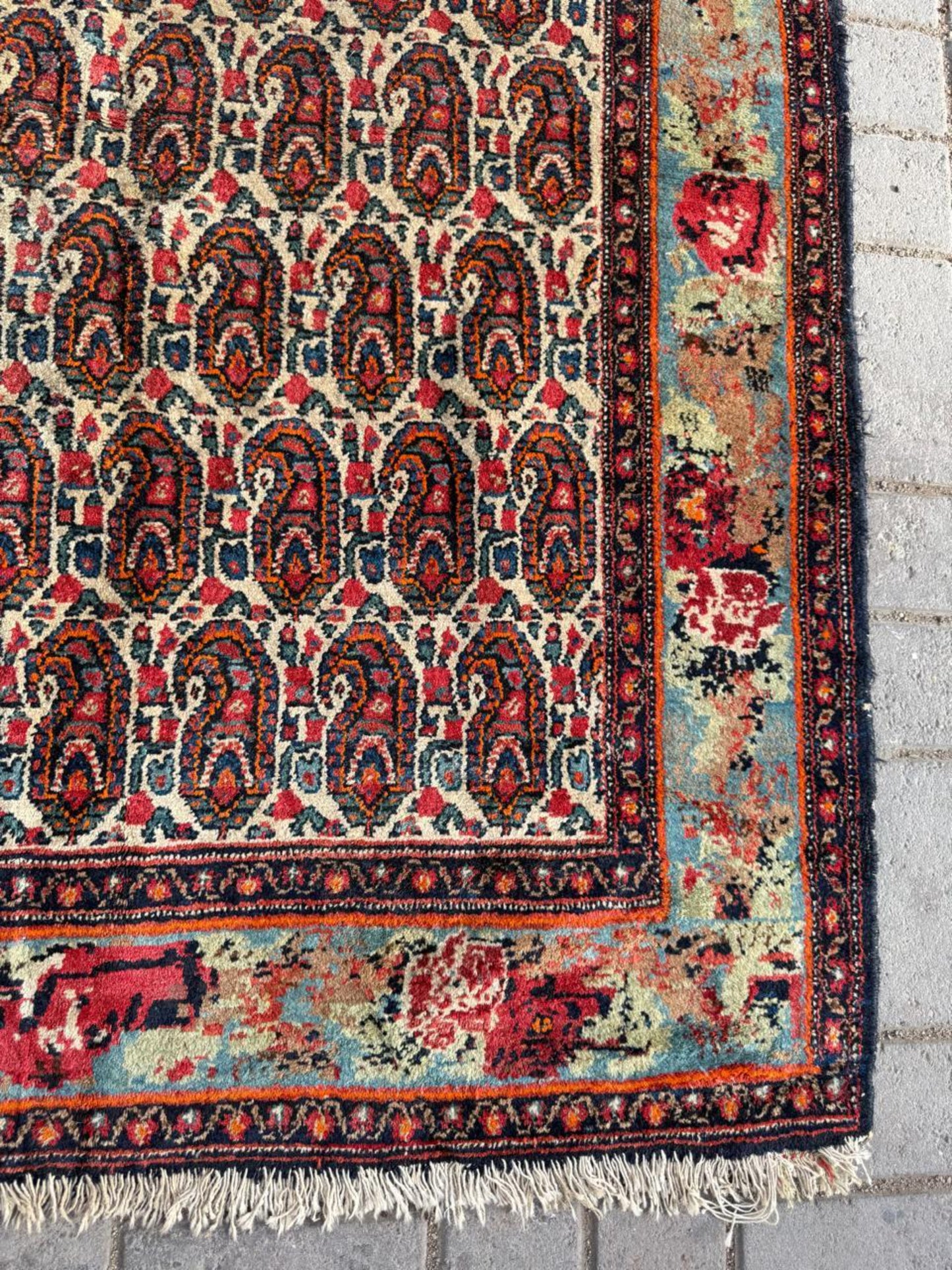 Brick red and sage green accents within Boteh designs

