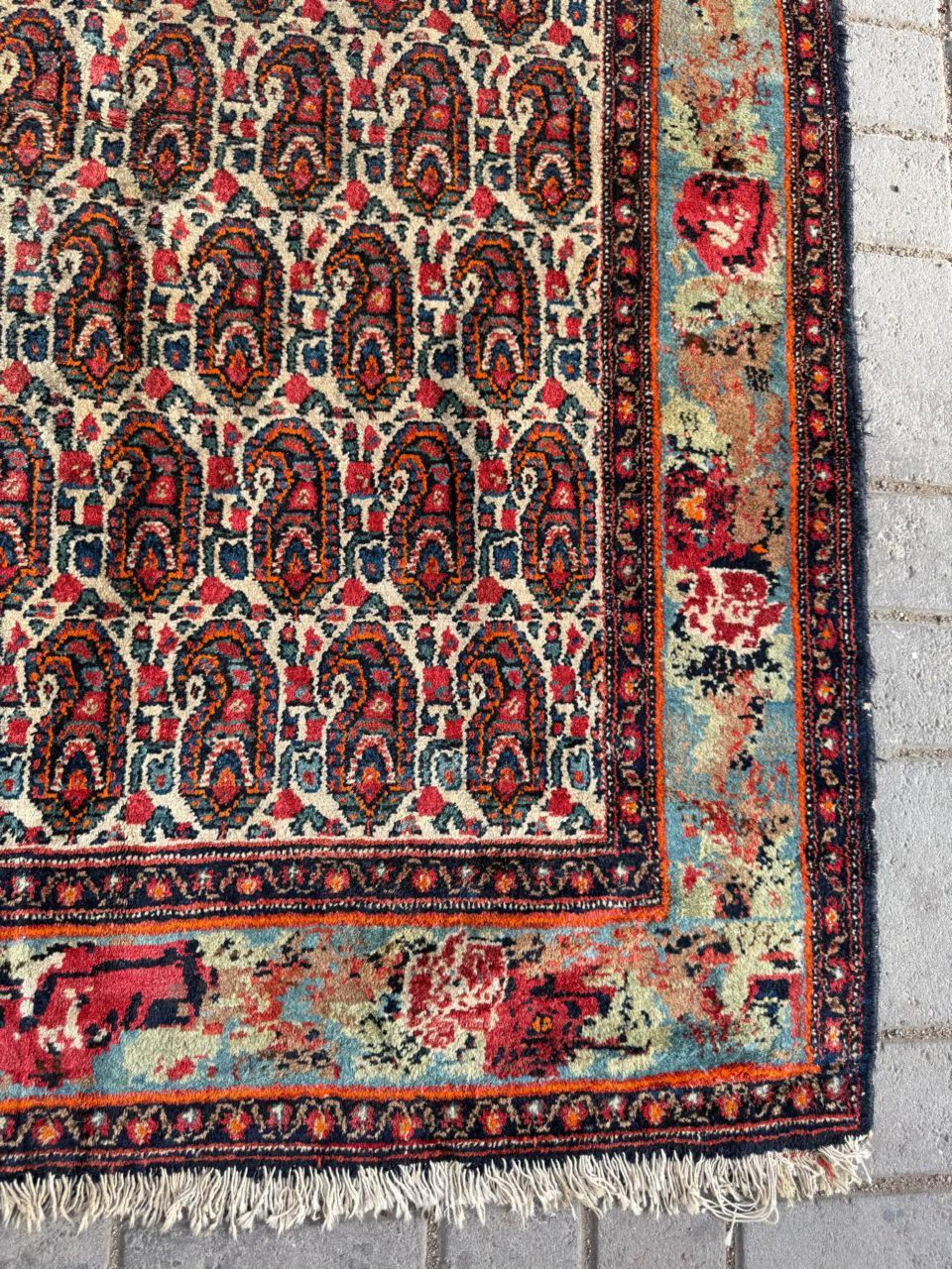 Brick red and sage green accents within Boteh designs

