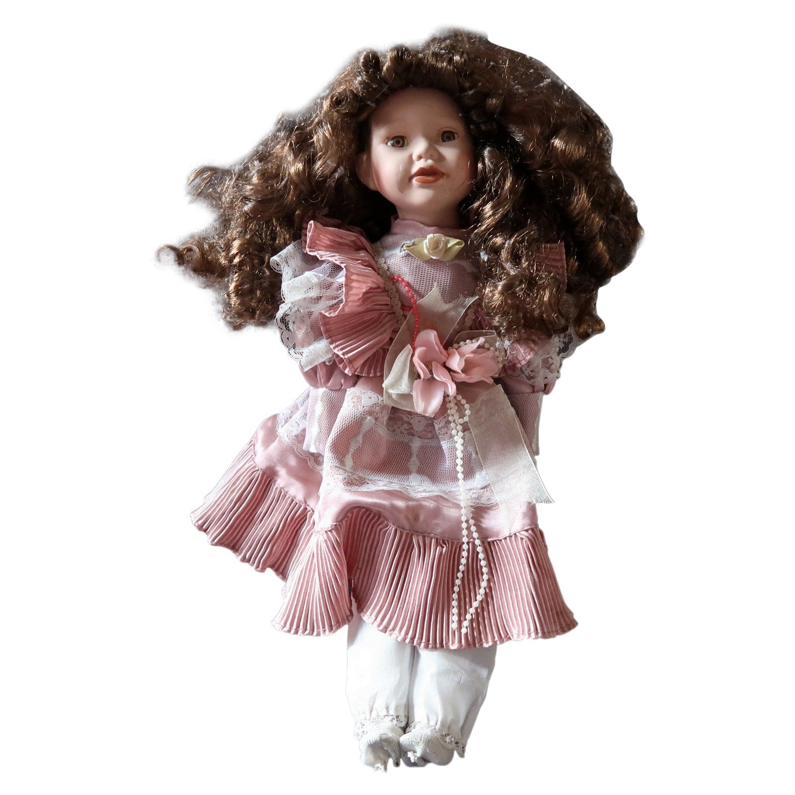Vintage porcelain doll in pink dress from the 20th century
