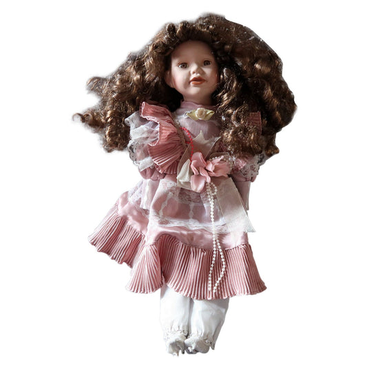 Vintage porcelain doll in pink dress from the 20th century

