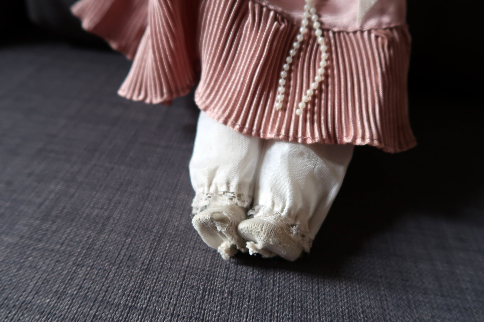 Close-up of vintage porcelain doll's delicate hand and face details
