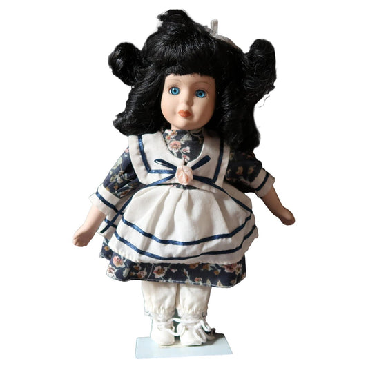 Vintage porcelain doll with blue and white dress
