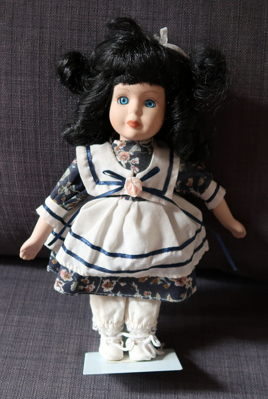 Mid-20th-century porcelain doll with black hair and blue eyes
