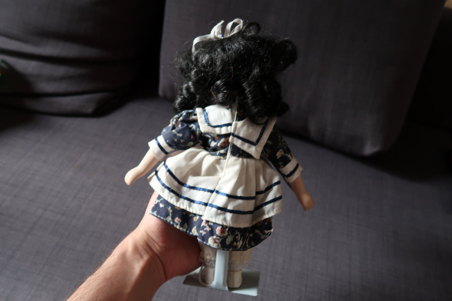 Porcelain doll with detailed facial features and fabric outfit
