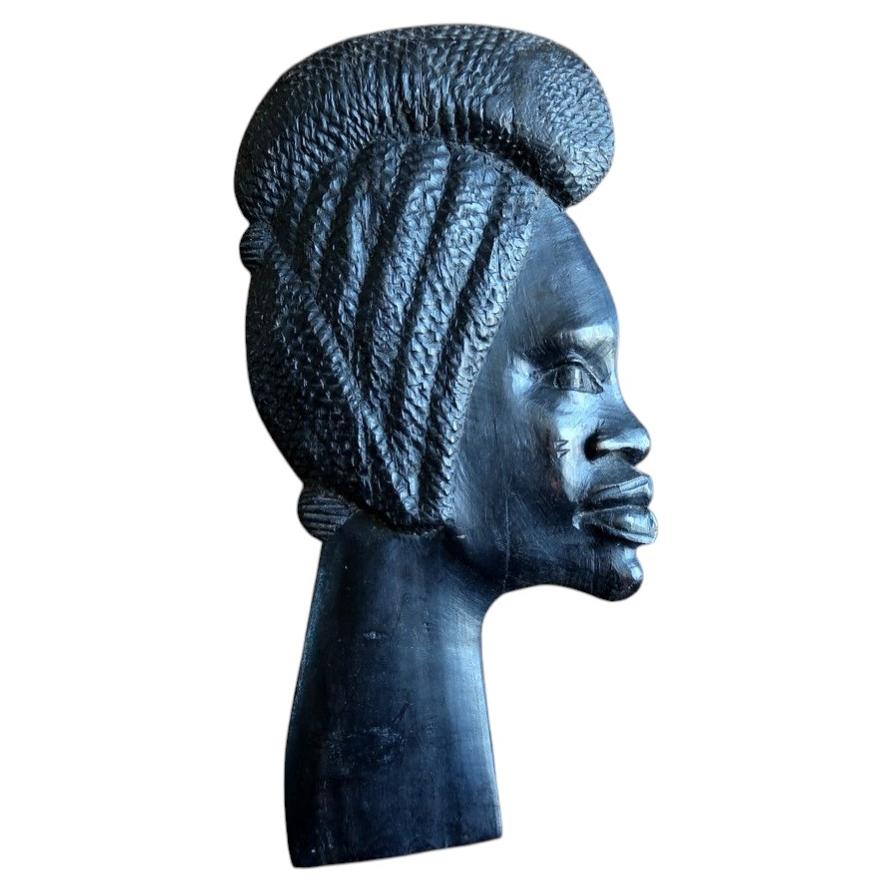 African ebonized hardwood wall plaque featuring a hand-carved female portrait inspired by Makonde tribal art aesthetics.