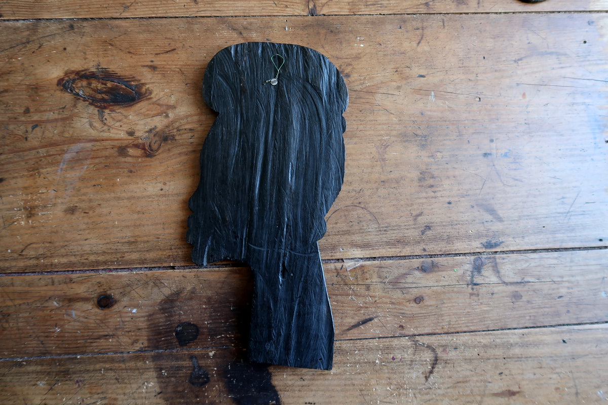 Sleek architectural contours and slim relief projection of a hand-carved African woman wall sculpture.